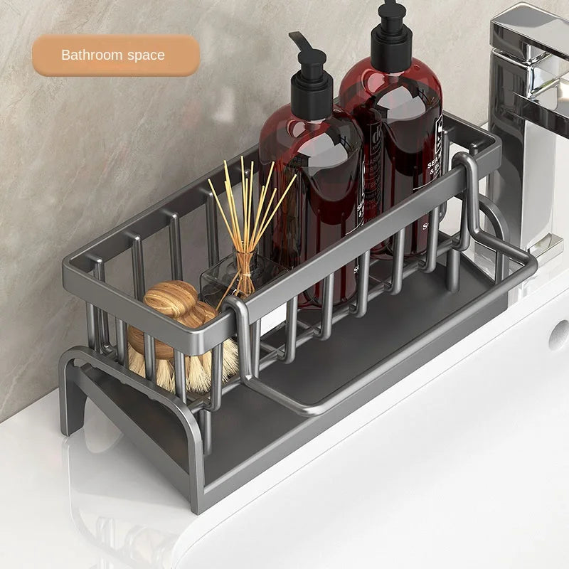 Modern gray kitchen sink organizer rack holding soap dispensers and cleaning brushes near faucet